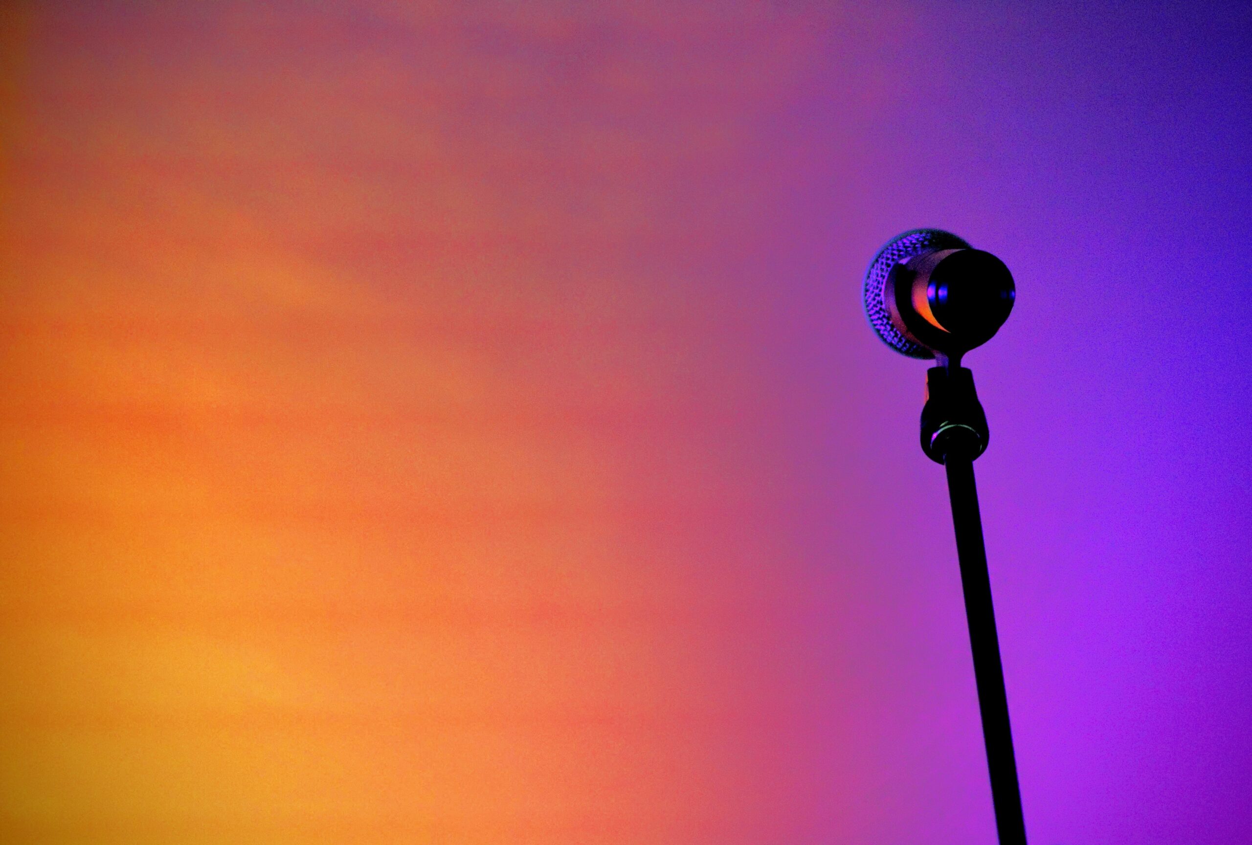 photo of a microphone in front of a orange and blue backround